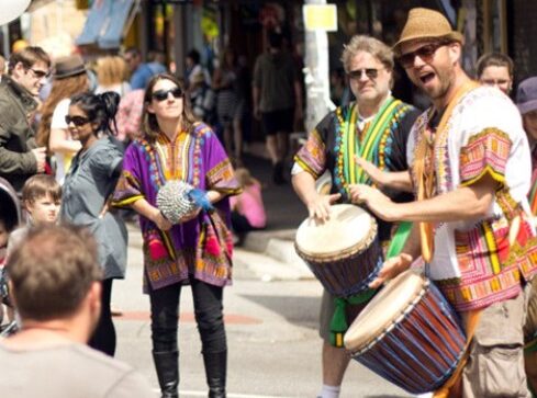 man performing at community event with djembe